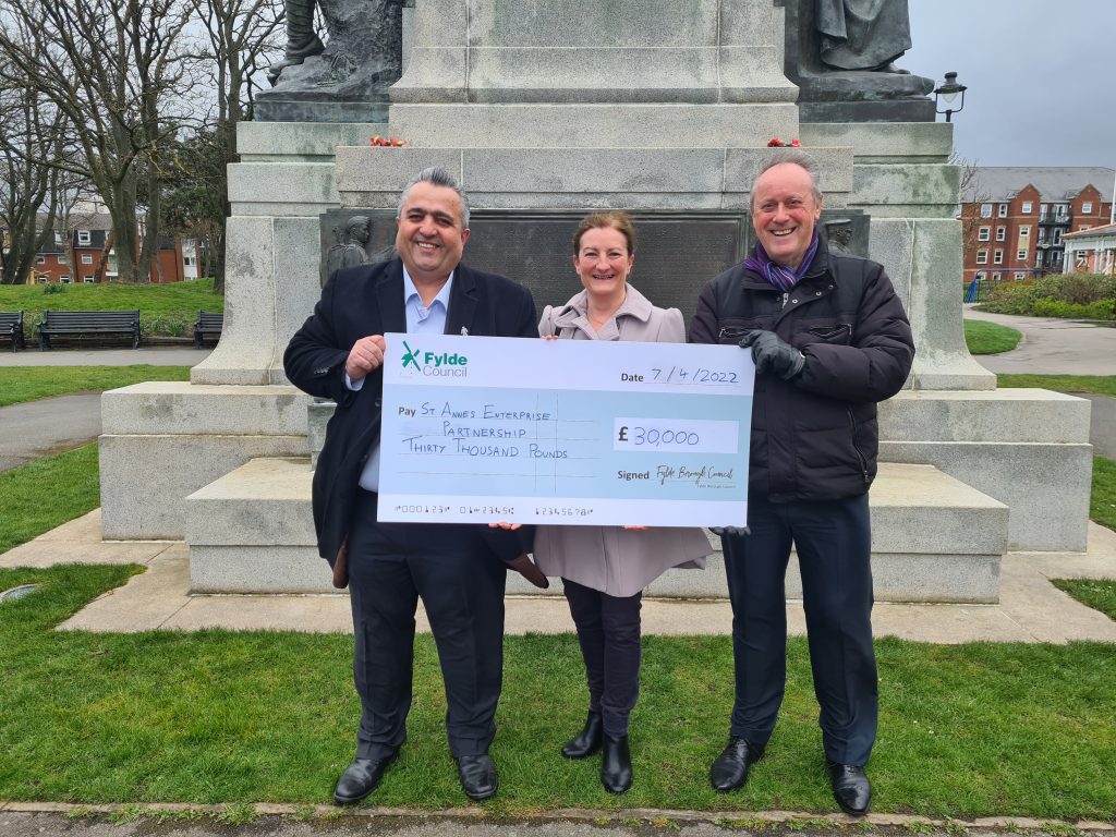 Cllr Roger Small [R], Deputy Leader of Fylde Council, presents cheque to Veli Kirk [L] and Aileen Aimes of St Annes Enterprise Partnership.